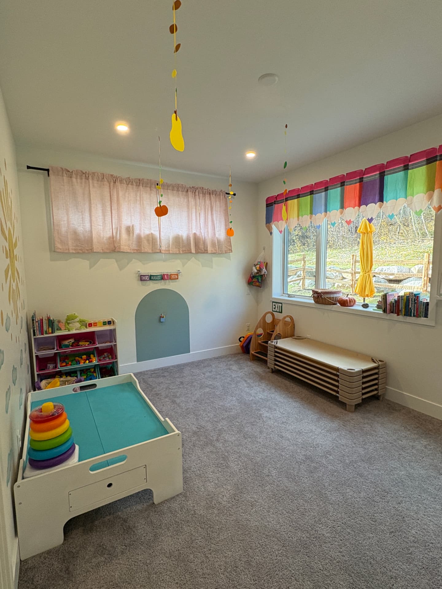 A bright playroom with crayon curtains, cozy cots, and a picture-book window
